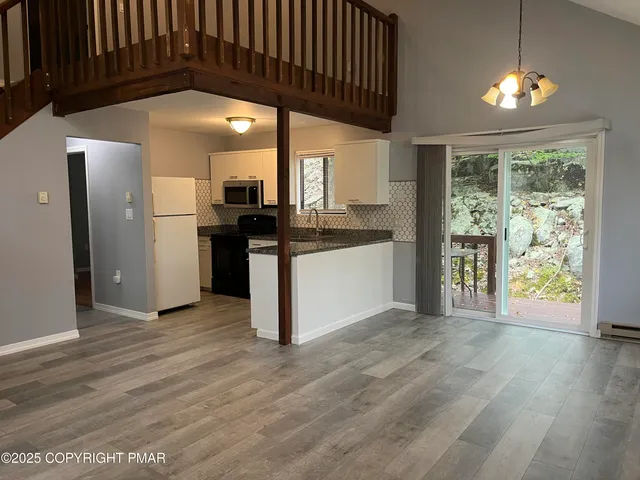 a view of a kitchen with a sink wooden floor and a refrigerator