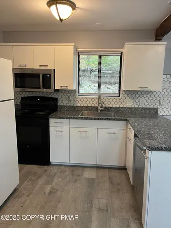 a kitchen with granite countertop a stove and a sink
