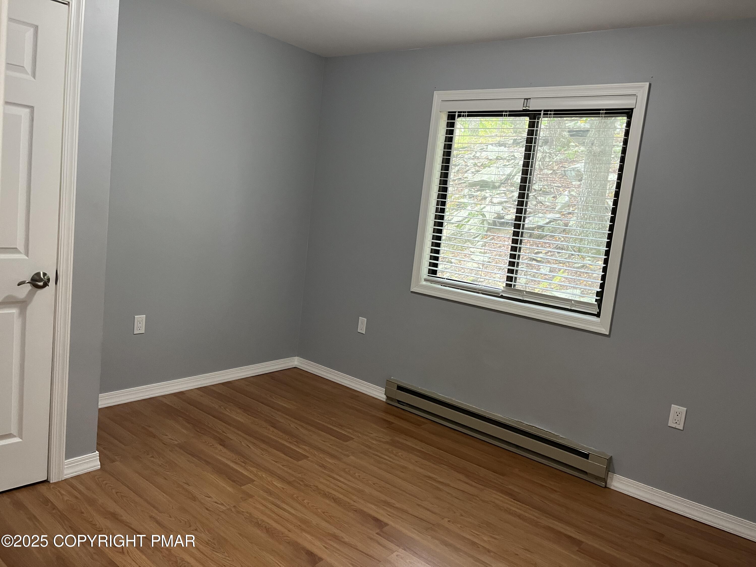 5031 Woodbridge Drive East Bushkill, PA 18324 - Photo 10 of 17 an empty room with wooden floor and windows