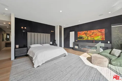 a spacious bedroom with a bed and a flat screen tv