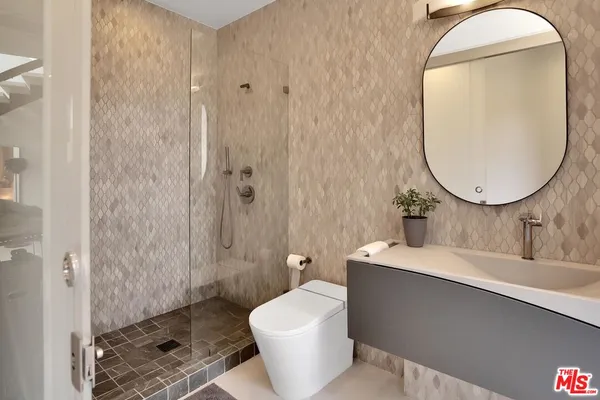 a bathroom with a sink mirror vanity and toilet