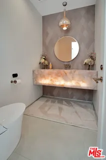 a bathroom with a sink a toilet a mirror and shower