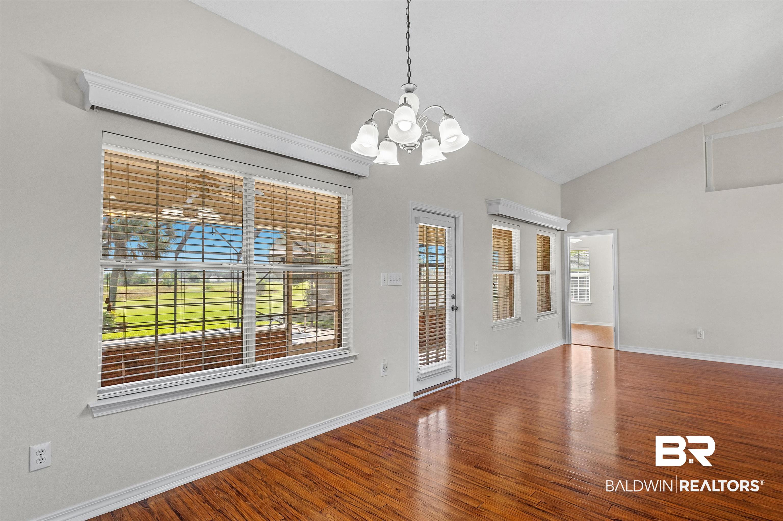 421 Collinwood Loop Foley, AL 36535 - Photo 29 of 62 Unfurnished room featuring a healthy amount of sunlight, hardwood / wood-style flooring, and a chandelier