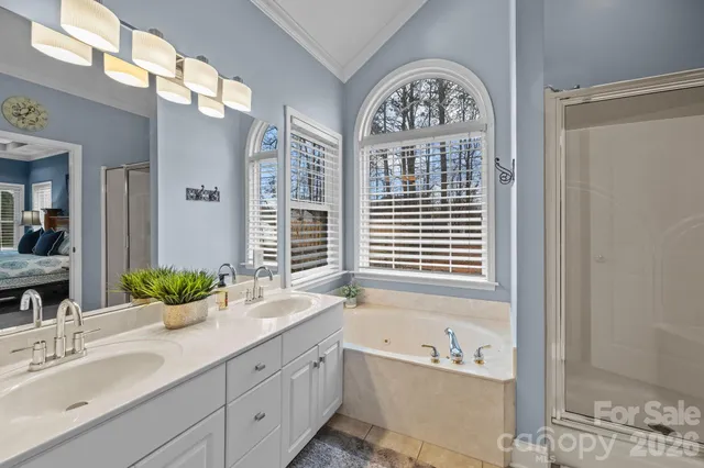 a bathroom with a granite countertop double vanity sink and a bathtub
