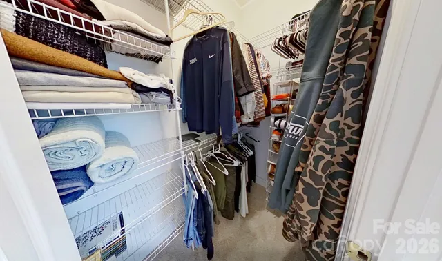 a view of walk in closet with clothes and shoes