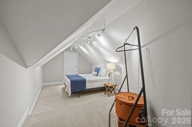 a bedroom with a bed a mirror and lamp