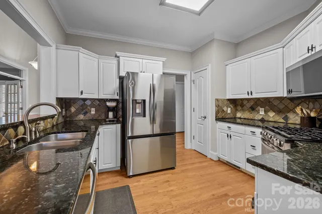 a kitchen with stainless steel appliances granite countertop a refrigerator sink and stove