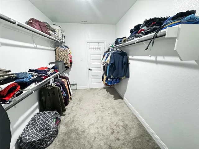 a view of walk in closet with clothes and shoes