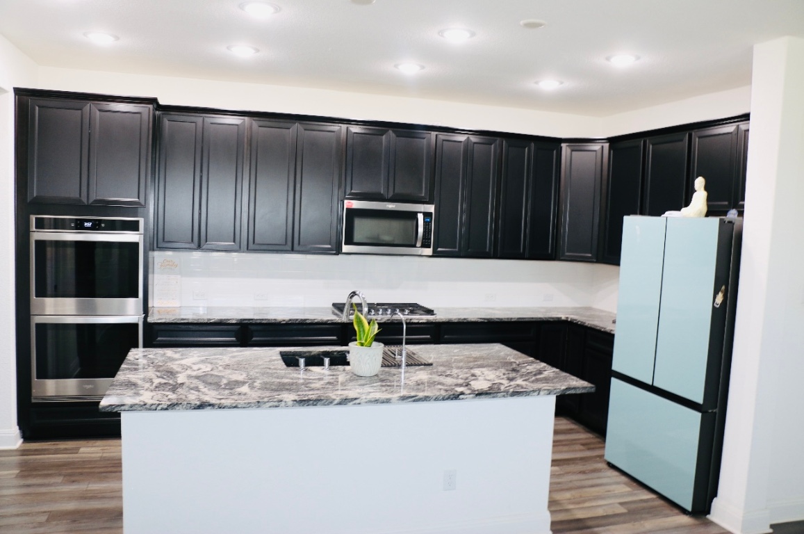302 Georgia Lace Trail Georgetown, TX 78626 - Photo 9 of 21 a kitchen with granite countertop a refrigerator and a stove top oven