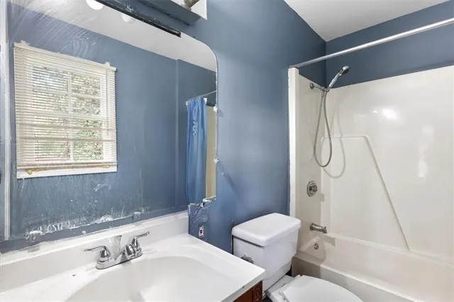 a bedroom with a bed and next to a window