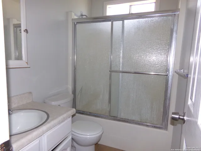 a bathroom with a granite countertop sink toilet and shower