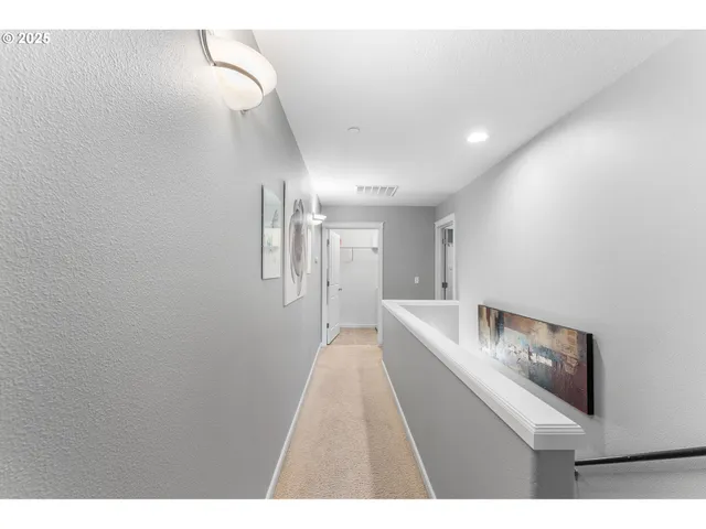 a hallway with white cabinets and wooden floor