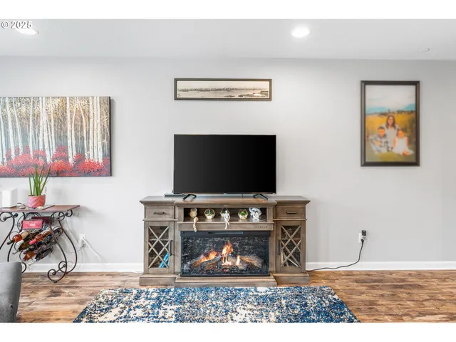 a living room with furniture a flat screen tv and a fireplace