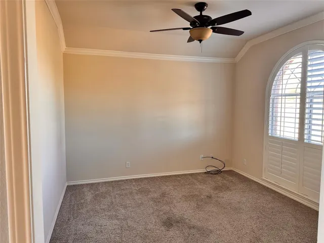 an empty room with a window and a fan