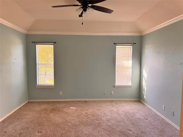 an empty room with a window and a ceiling fan