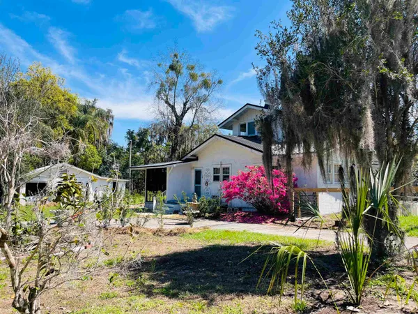 a front view of a house with yard and green space
