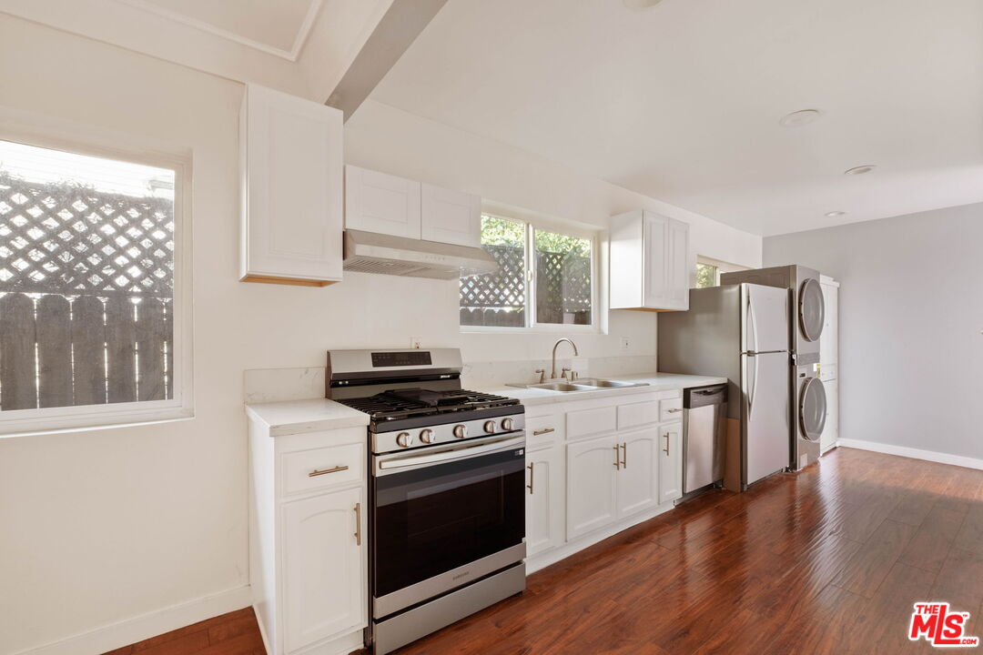 838 North Ridgewood Place Los Angeles, CA 90038 - Photo 12 of 23 a kitchen with stainless steel appliances a stove a sink and a refrigerator