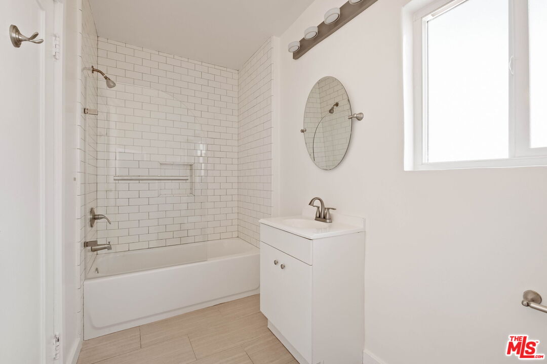 838 North Ridgewood Place Los Angeles, CA 90038 - Photo 18 of 23 a bathroom with a bath tub a sink and a window