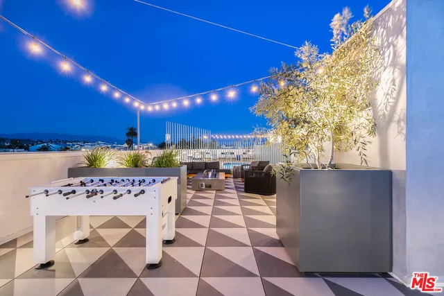 a patio with a dining table chairs and a kitchen