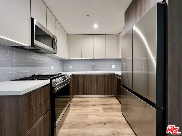 a kitchen with stainless steel appliances granite countertop a stove a microwave and a refrigerator