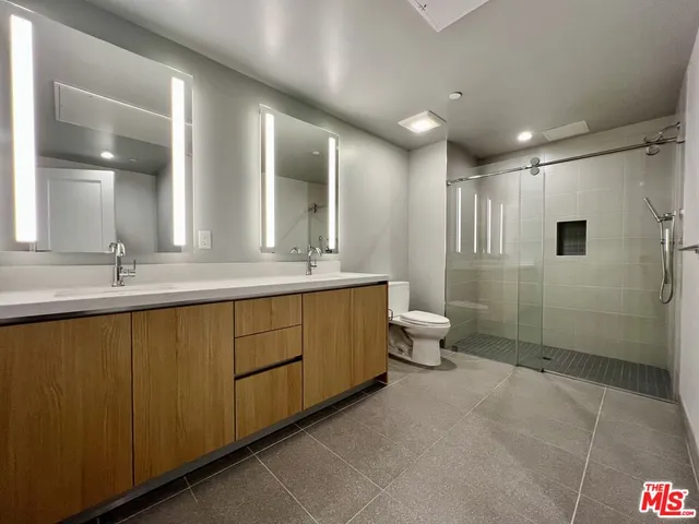 a bathroom with a double vanity sink toilet and a mirror