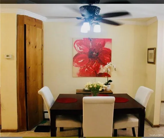 a view of a dining room with furniture and a chandelier fan