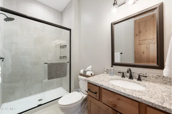 a bathroom with a granite countertop sink toilet and shower