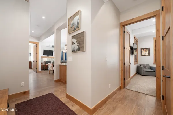 a view of a hallway with bathroom and wooden floor