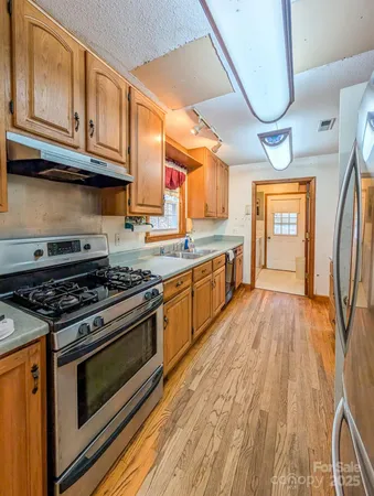 a kitchen with stainless steel appliances granite countertop a stove and a sink
