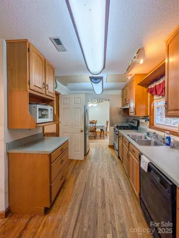 a kitchen with stainless steel appliances granite countertop a stove a sink and a refrigerator