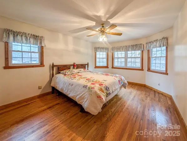 a bedroom with a large bed chandelier and a window