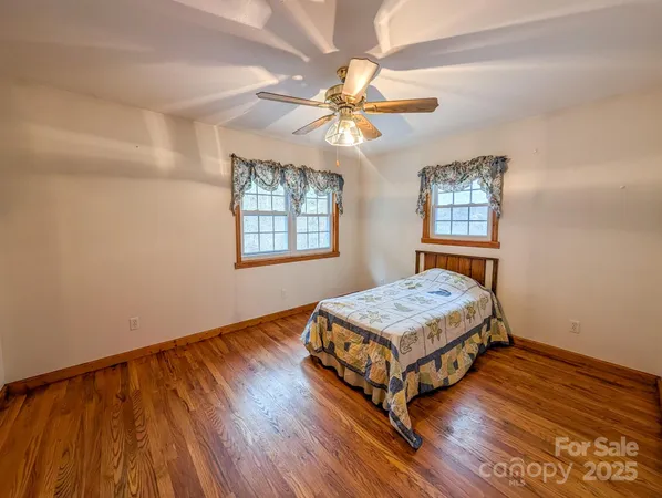 a living room with hard wood floors and a ceiling fan