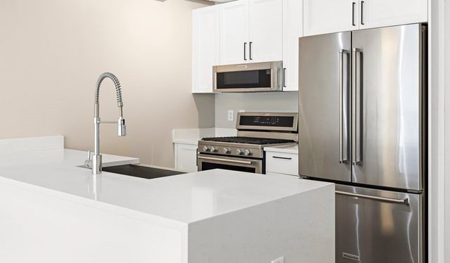 a kitchen with stainless steel appliances a refrigerator and a sink