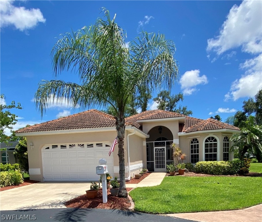 9012 West Ridge Court Fort Myers, FL 33912 - Photo 1 of 23 a front view of a house with a garden and a yard