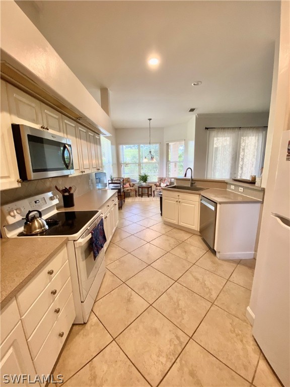 9012 West Ridge Court Fort Myers, FL 33912 - Photo 4 of 23 a kitchen with granite countertop a sink a stove top oven a counter space and cabinets