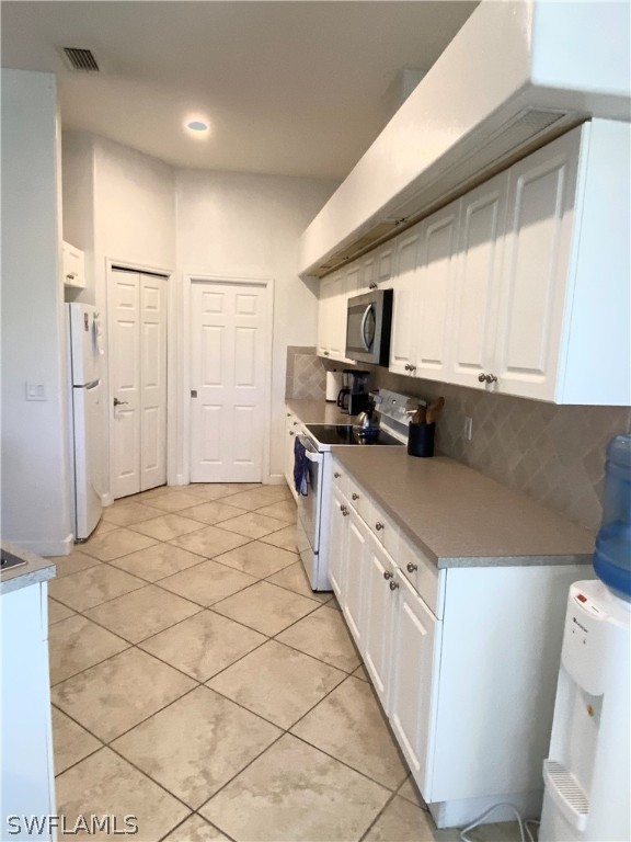 9012 West Ridge Court Fort Myers, FL 33912 - Photo 6 of 23 a kitchen with stainless steel appliances a refrigerator a sink and white cabinets
