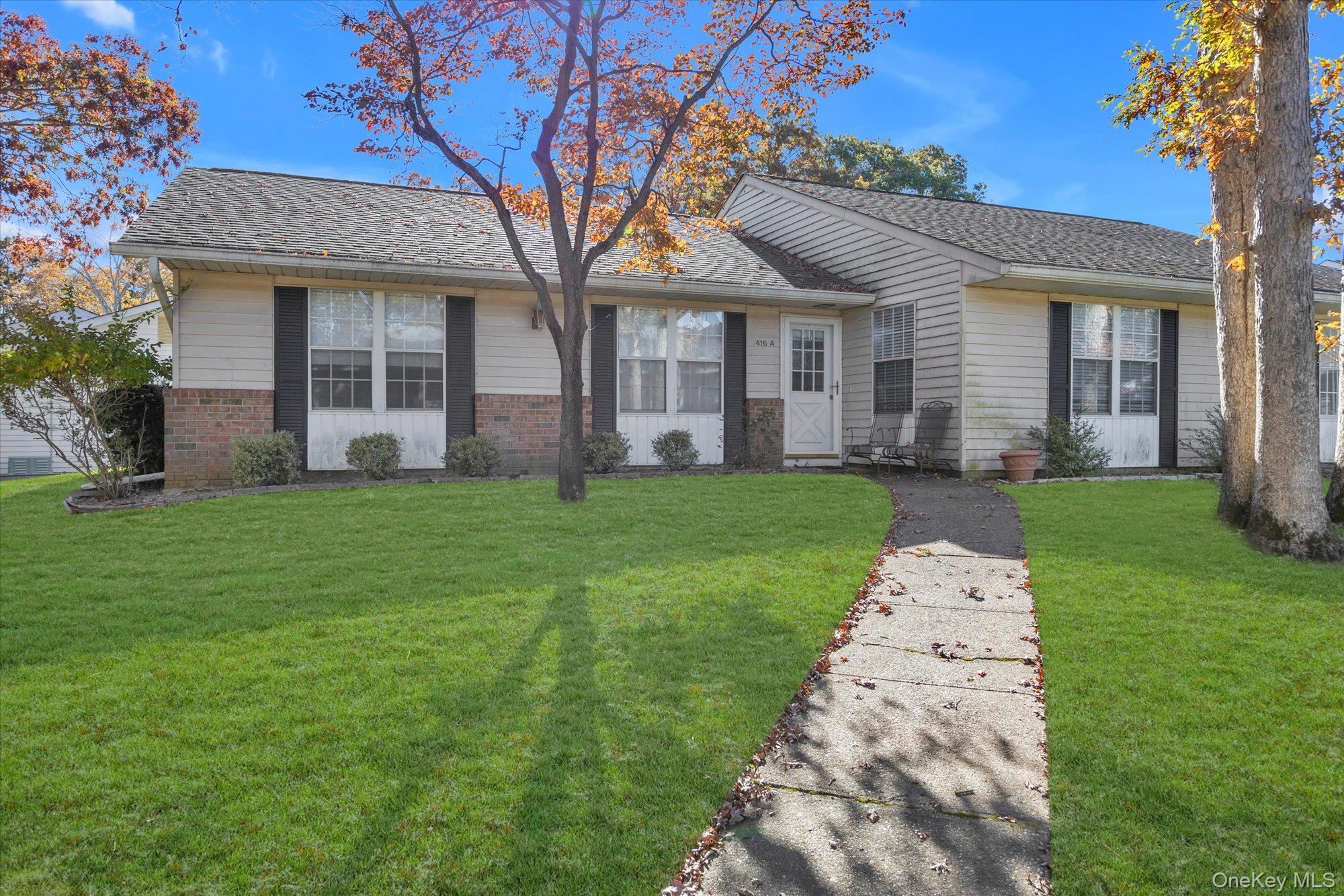 front view of a brick house with a yard
