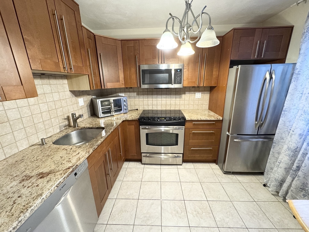 92 Gordon Street, Unit 301 Boston, MA 02135 - Photo 2 of 15 a kitchen with stainless steel appliances granite countertop a refrigerator a sink a stove a microwave and island