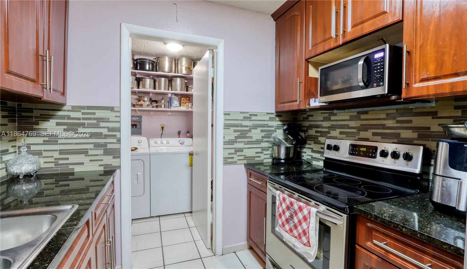 15825 Southwest 305th Terrace Homestead, FL 33033 - Photo 13 of 36 a kitchen with stainless steel appliances granite countertop a stove and a microwave