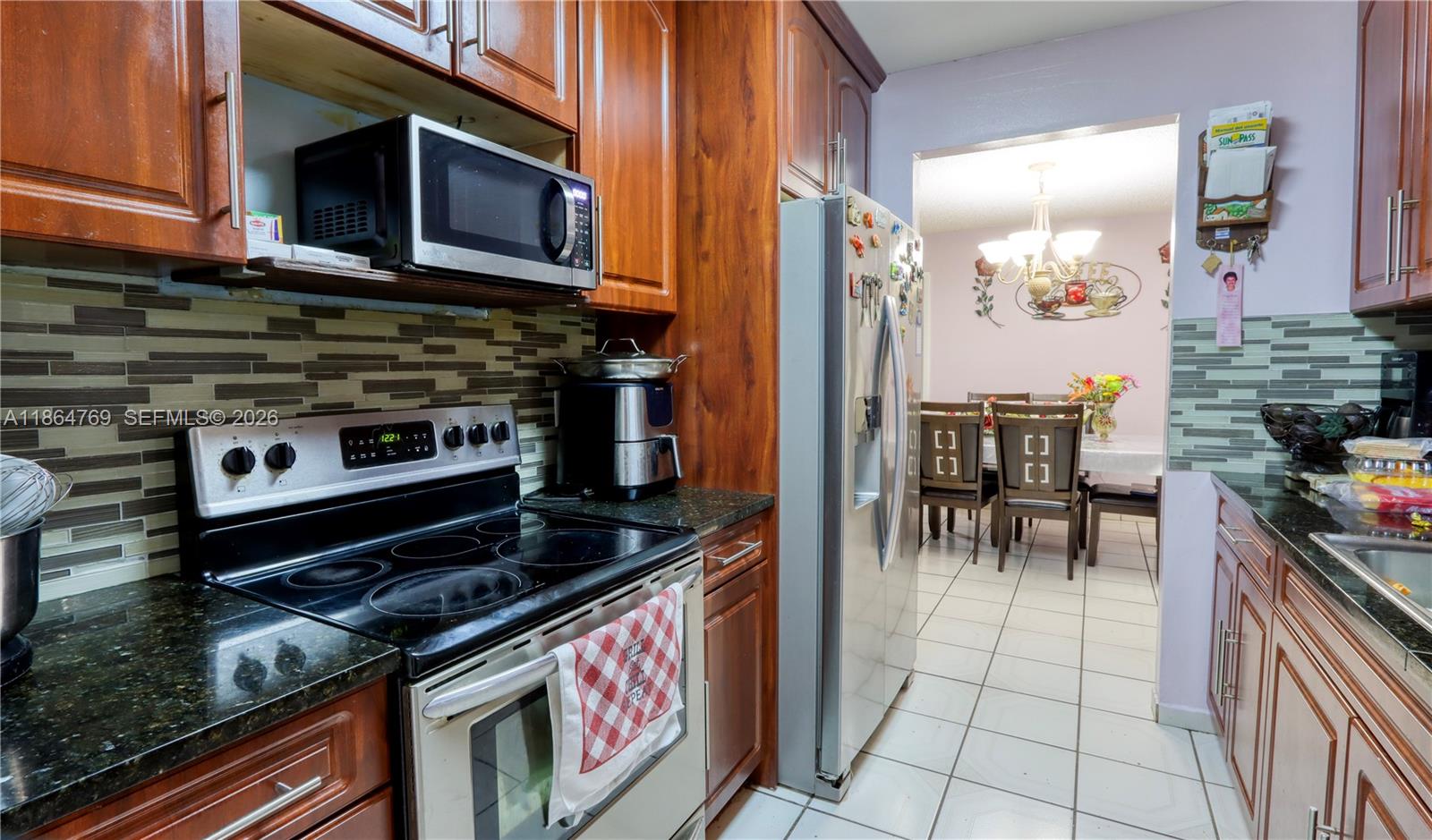 15825 Southwest 305th Terrace Homestead, FL 33033 - Photo 16 of 36 a kitchen with stainless steel appliances granite countertop a stove a sink and a microwave