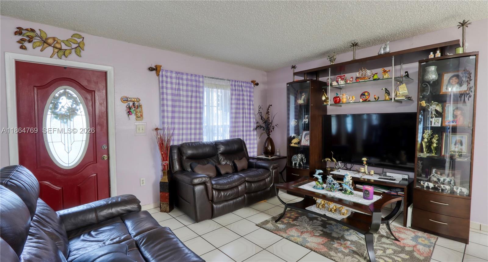 15825 Southwest 305th Terrace Homestead, FL 33033 - Photo 19 of 36 a living room with furniture a flat screen tv and a window