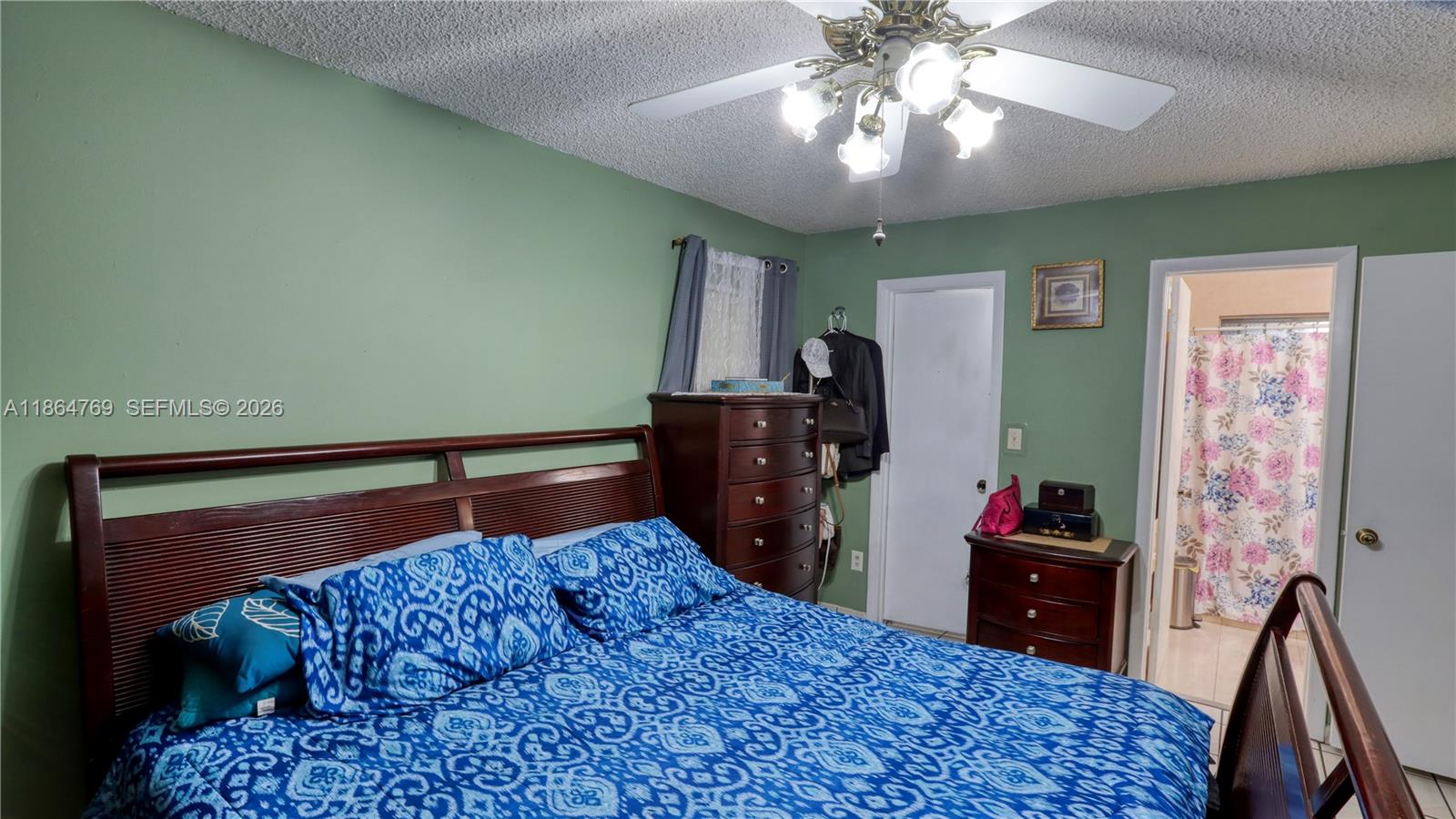 15825 Southwest 305th Terrace Homestead, FL 33033 - Photo 26 of 36 a bedroom with a bed and a chandelier
