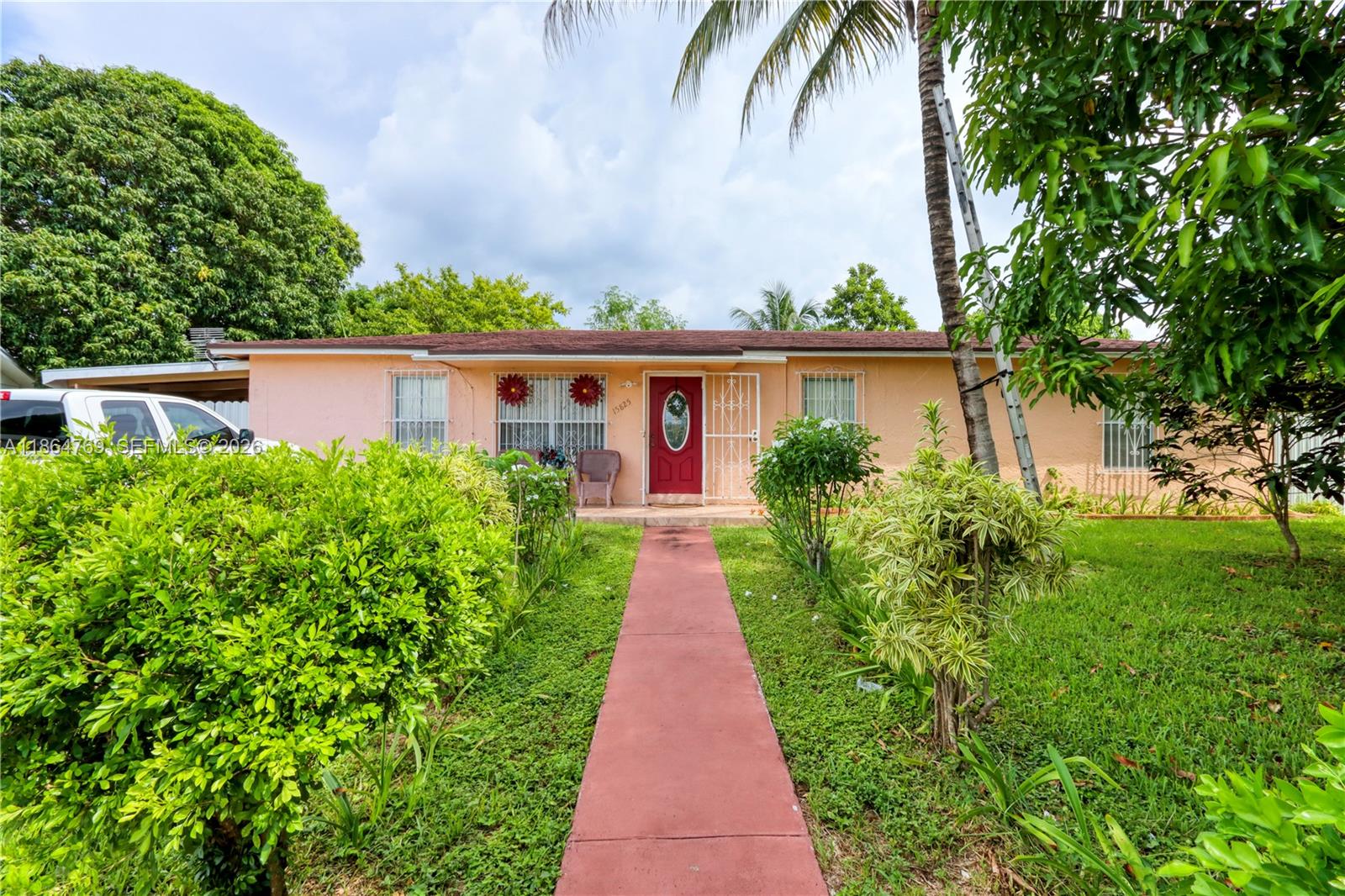 15825 Southwest 305th Terrace Homestead, FL 33033 - Photo 4 of 36 a view of a house with potted plants next to a yard