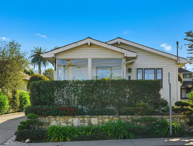 a front view of a house with a garden
