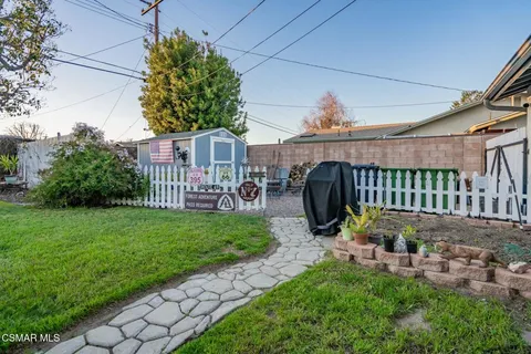 a backyard of a house with table and chairs