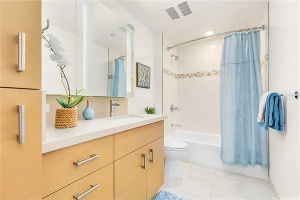 a bathroom with a granite countertop sink a toilet and shower