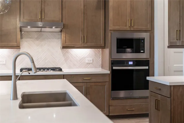 a kitchen with granite countertop white cabinets and stainless steel appliances