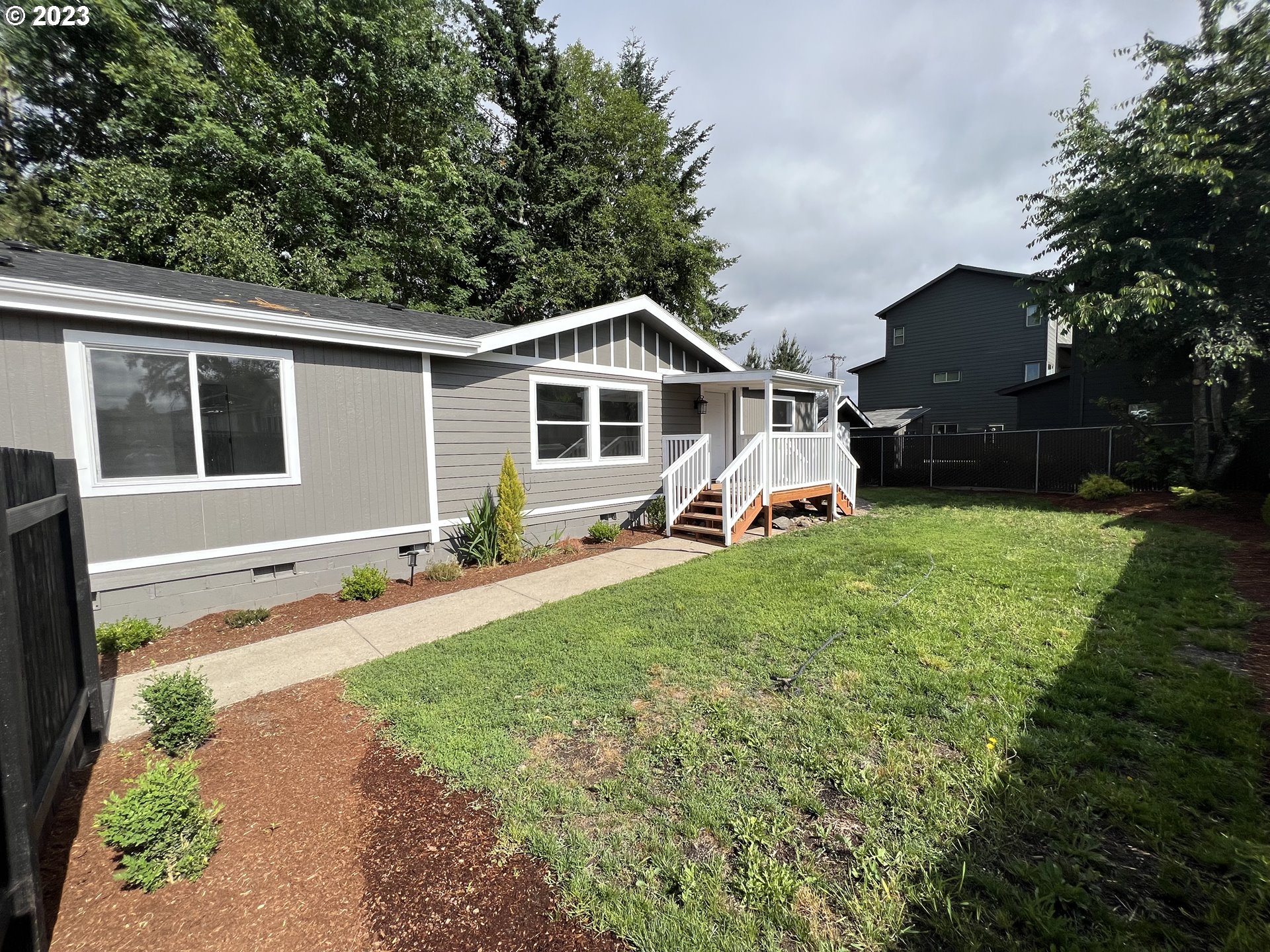 a front view of a house with a garden and trees
