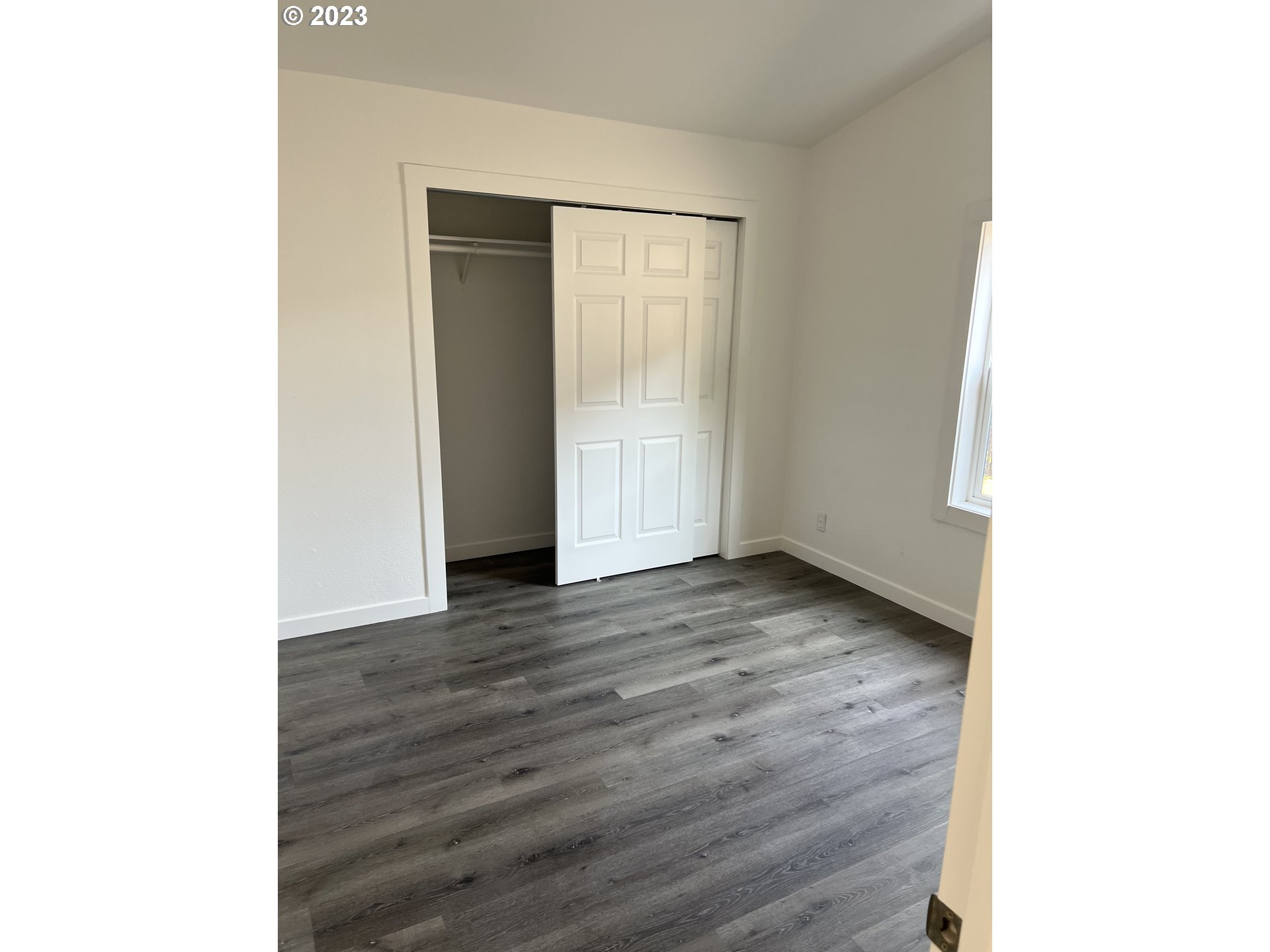 170 Fenton Avenue Molalla, OR 97038 - Photo 12 of 27 a view of an empty room with wooden floor and a window