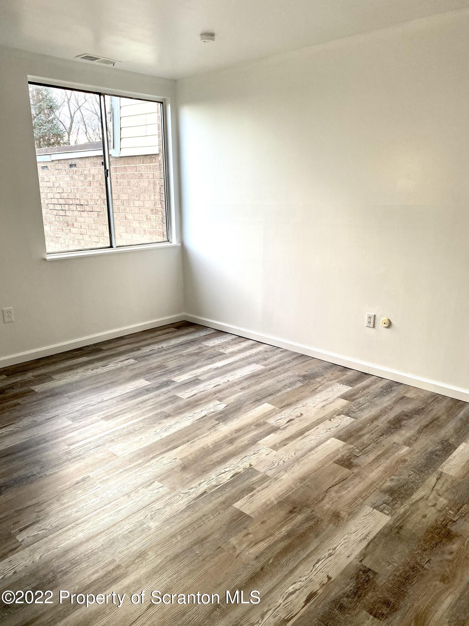 1111 Summit Pointe Scranton, PA 18508 - Photo 18 of 22 an empty room with wooden floor and windows